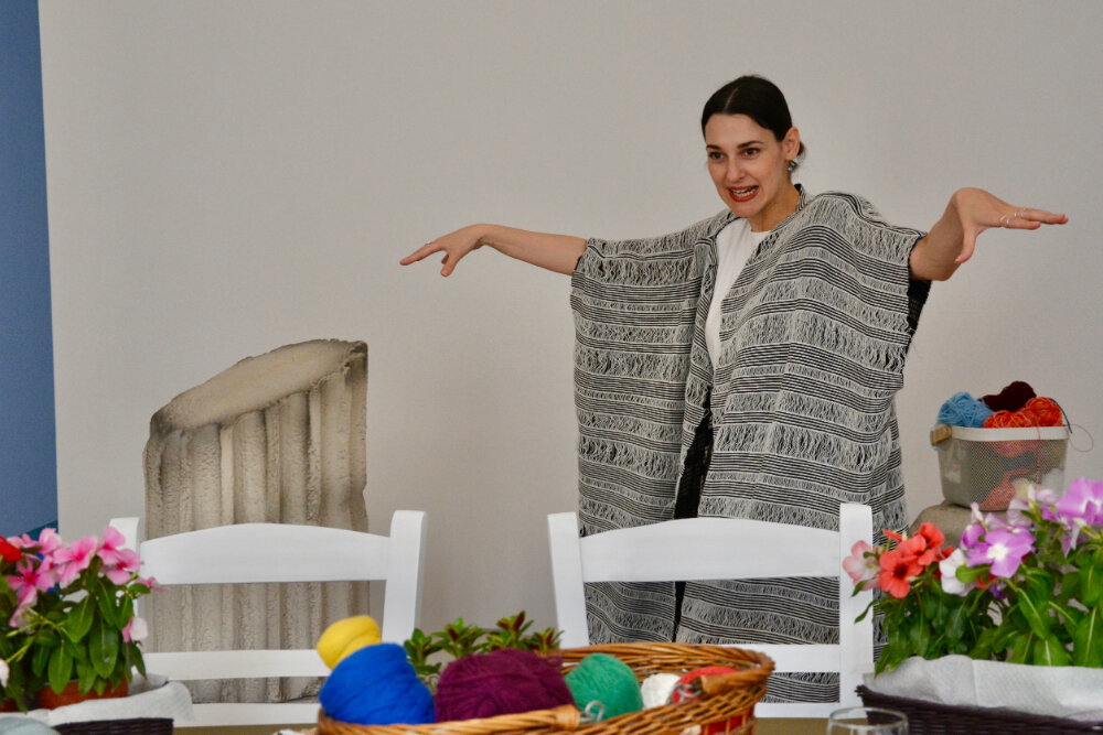 Instructor wearing a handwoven shawl presenting materials at the immersive weaving workshop in Athens