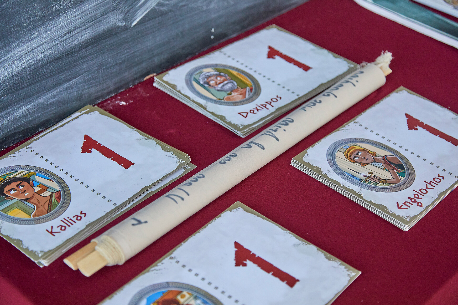 Hand-illustrated character cards and scroll used in the Who Killed Callimachos interactive murder mystery game