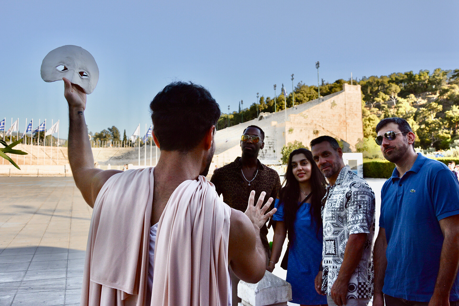 Costumed actor in a Greek mask performing during an Athens Living Museum interactive theatre experience