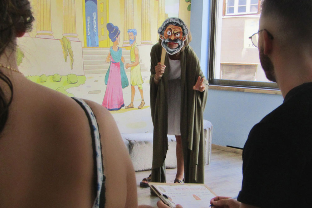 Costumed actor engaging guests during the Who Killed Callimachos interactive murder mystery night in Athens